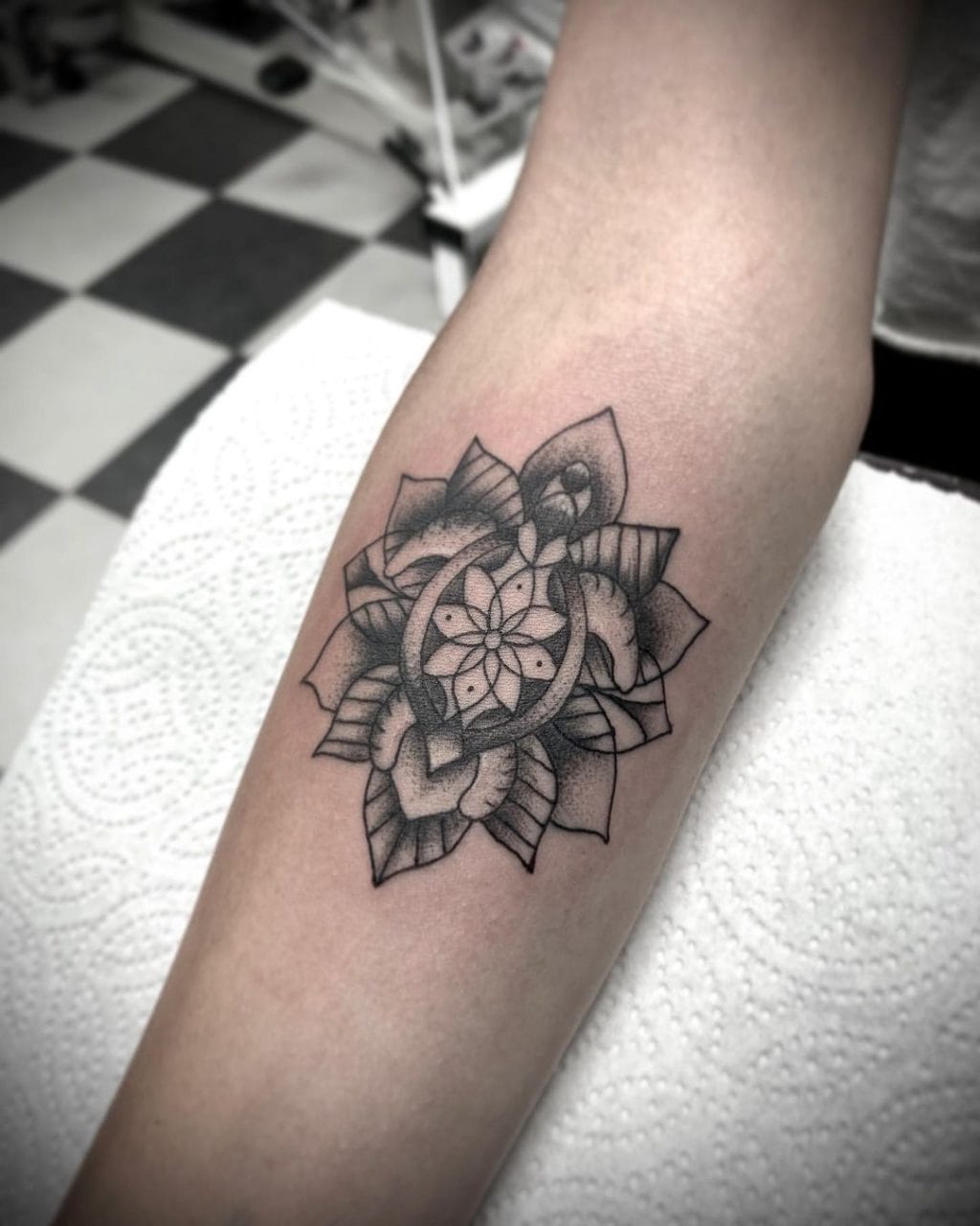 Lotus mandala turtle tattoo in black and grey on the forearm