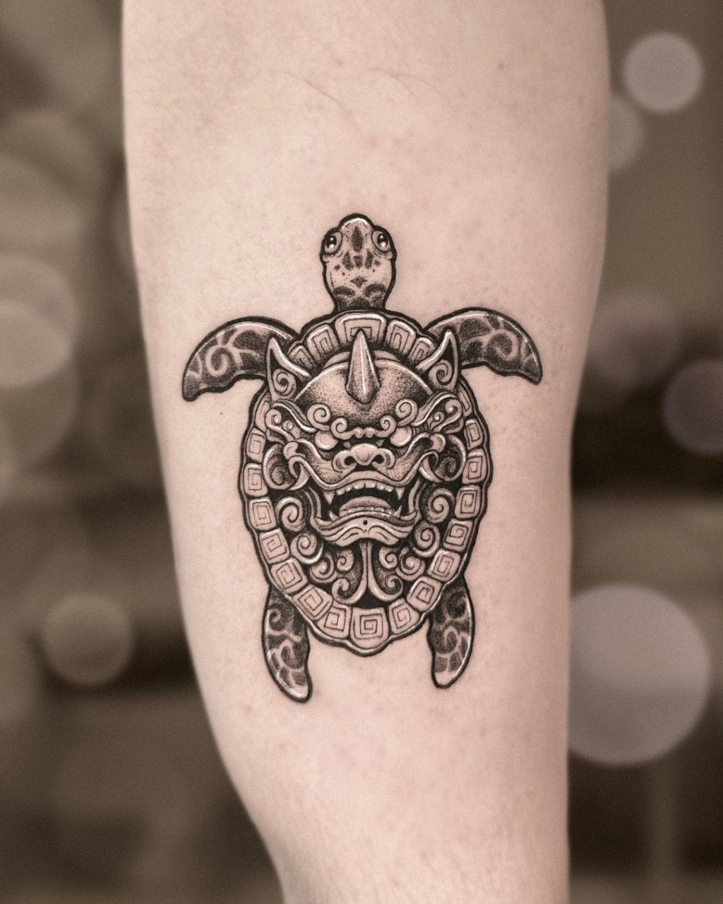 Foo dog sea turtle hybrid tattoo on the calf in black and grey