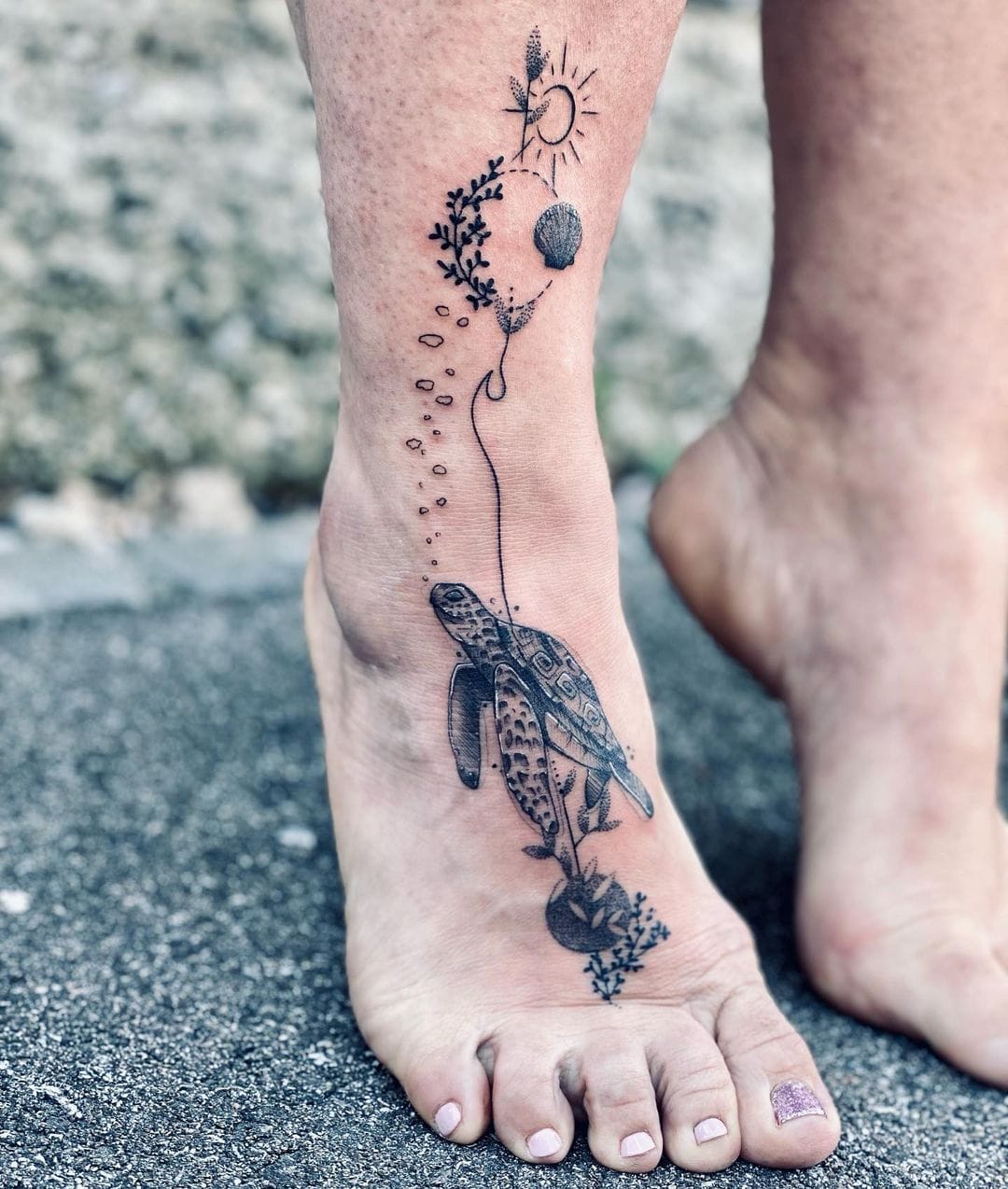 Fine-line turtle tattoo walking up the foot toward a dotwork sun