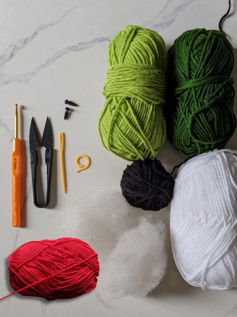 Christmas tortoise materials — milk cotton yarn in dark green, light green, red, black and white, plus 5mm safety eyes, 3.5mm hook, and craft glue