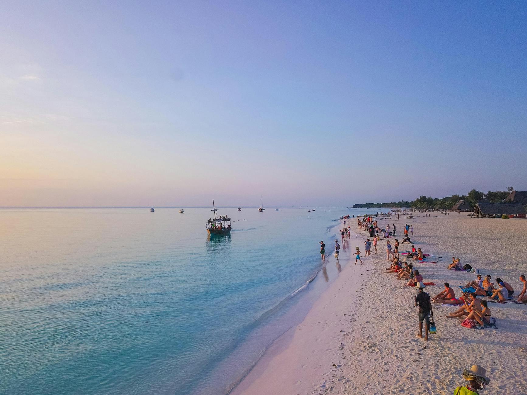 Zanzibar beach with a traditional dhow boat at sunset, near Mnemba Island's protected turtle reef