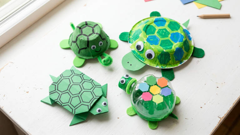 A collection of finished 3D turtle crafts made by kids from egg cartons, paper bowls, and plastic bottles with googly eyes