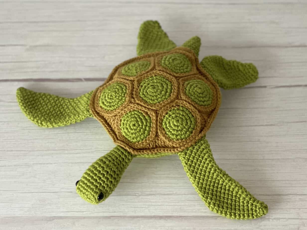 Two-tone hexagon shell crochet sea turtle with a contrasting belly and sleepy eyes