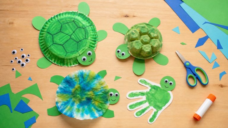 A collection of easy kid-made sea turtle crafts including a paper plate turtle, egg carton turtle, and handprint turtle arranged on a table