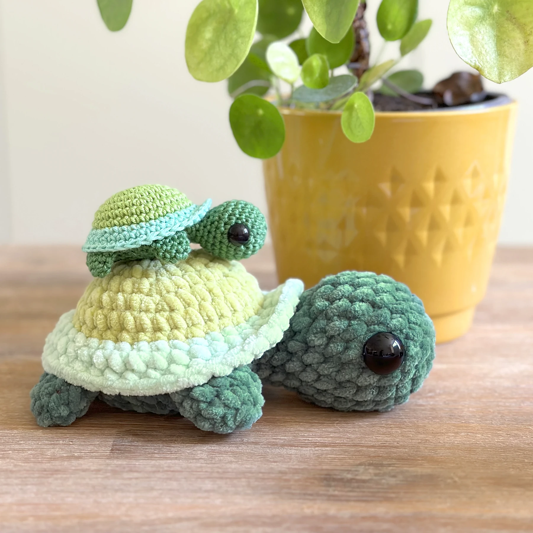Mini green and mint crochet sea turtle held in a hand