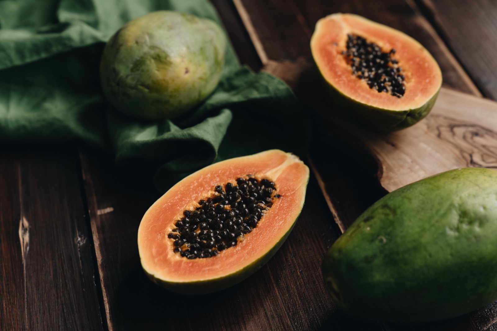 Sliced ripe papaya on a wooden board, one of the best fruits for red footed tortoises